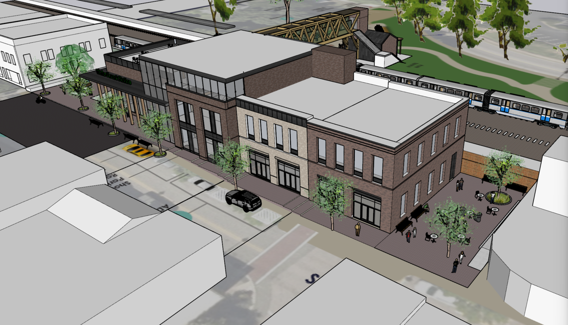 A rendering of a different version of a proposed train station in downtown Wake Forest. White Street is in the foreground, with a pedestrian bridge over the tracks to a planned drop-off and pick-up area on East South Street.