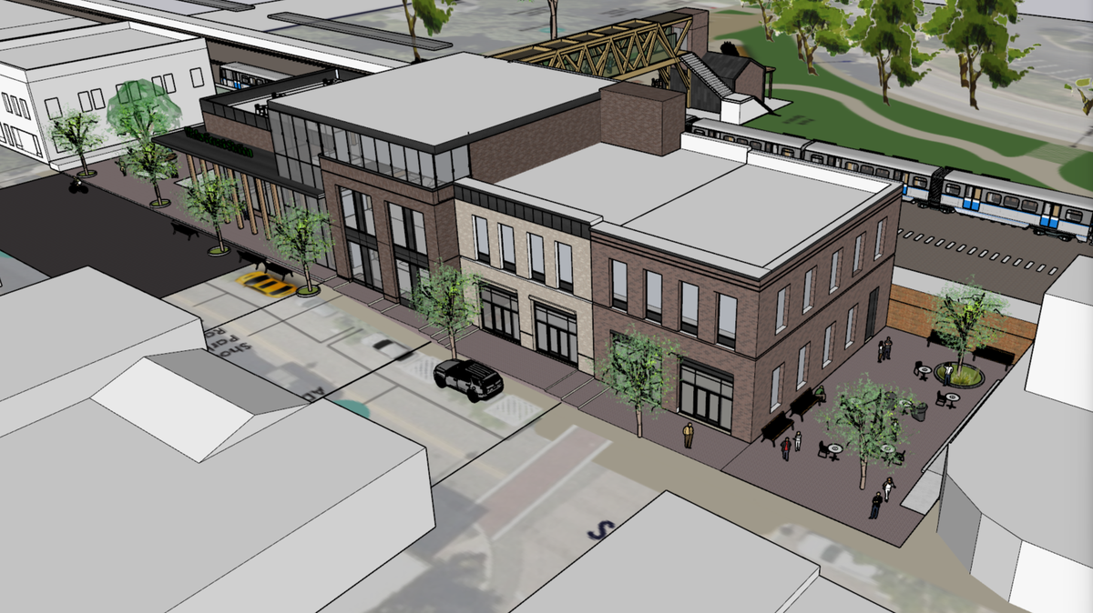 A rendering of a proposed train station in downtown Wake Forest. White Street is in the foreground, with a pedestrian bridge over the tracks to a planned drop-off and pick-up area on East South Street.
