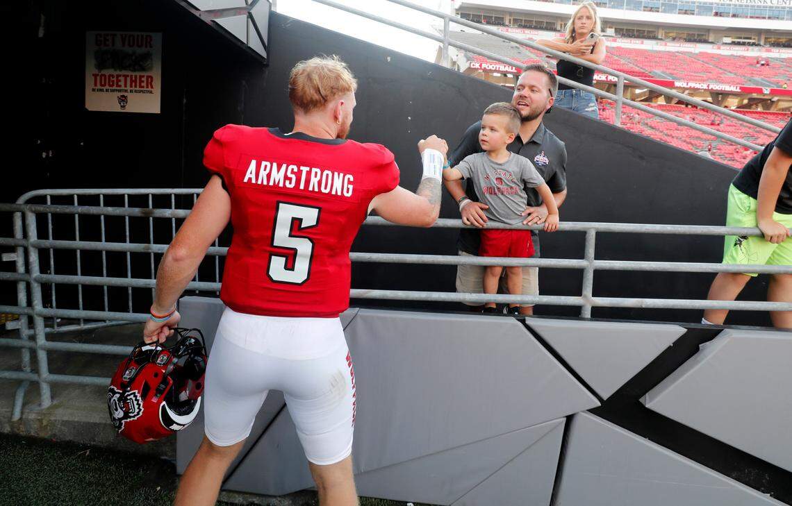 N.C. State quarterback Brennan Armstrong (5) greets Lance Stallings and his son, Cade, 3, after the Wolfpack’s 45-7 victory over VMI at Carter-Finley Stadium in Raleigh, N.C., Saturday, Sept. 16, 2023.