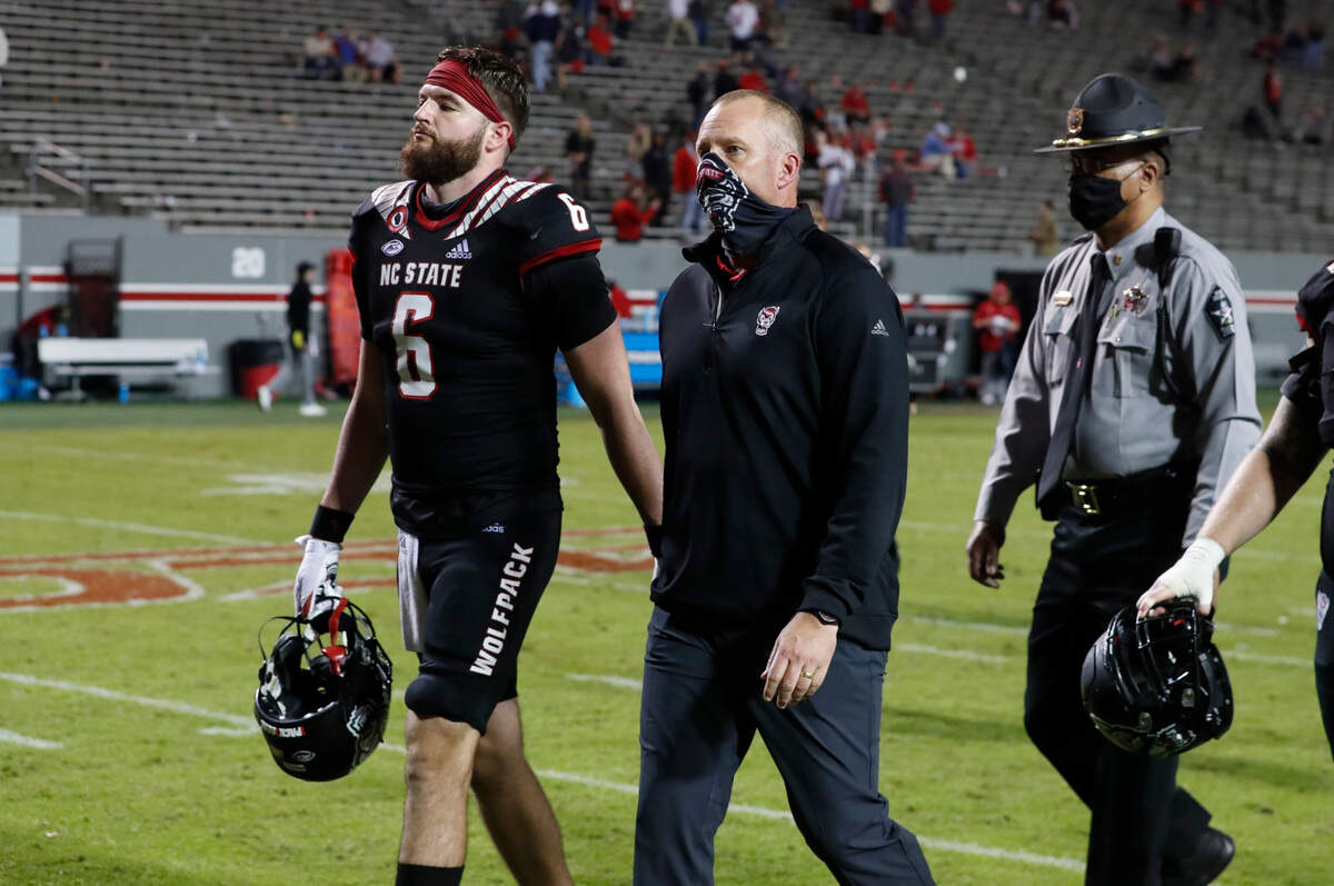 N.C. State head coach Dave Doeren and tight end Cary Angeline (6) walk off the field after Miami’s 44-41 victory over N.C. State at Carter-Finley Stadium in Raleigh, N.C., Friday, Nov. 6, 2020.