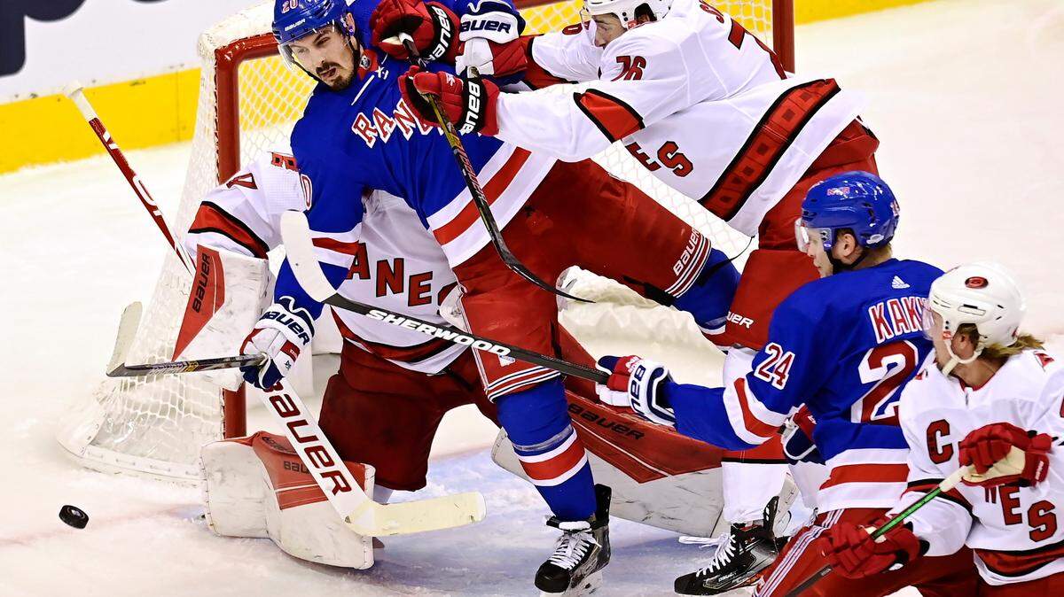 New York Rangers’ Chris Kreider (20) is hit by Carolina Hurricanes’ Brady Skjei (76) in front of Hurricanes goaltender James Reimer (47) during first period NHL Eastern Conference Stanley Cup playoff action in Toronto on Tuesday, Aug. 4, 2020. (Frank Gunn/The Canadian Press via AP)