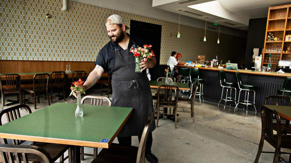 Chef Chris Lopez adds flowers to vases at Fine Folk restaurant in Raleigh on Wednesday afternoon, April 13, 2022.