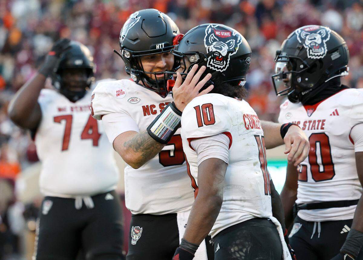 N.C. State quarterback Brennan Armstrong (5) celebrates with wide receiver KC Concepcion (10) after Conception scored on a 28-yard touchdown reception during the first half of N.C. State’s game against Virginia Tech at Lane Stadium in Blacksburg, VA, Saturday, Nov. 18, 2023.