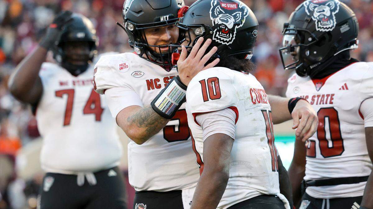 N.C. State quarterback Brennan Armstrong (5) celebrates with wide receiver KC Concepcion (10) after Conception scored on a 28-yard touchdown reception during the first half of N.C. State’s game against Virginia Tech at Lane Stadium in Blacksburg, VA, Saturday, Nov. 18, 2023.