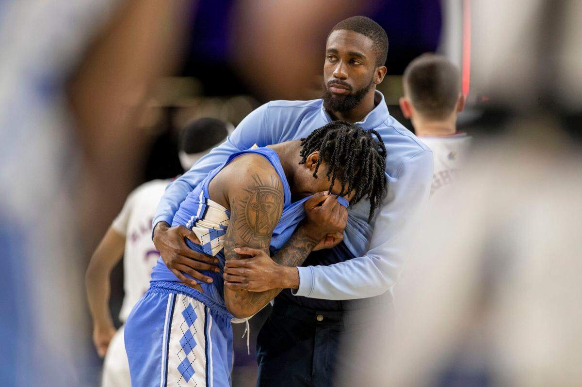 North Carolina graduate assistant Brandon Robinson consoles Caleb Love (2) after Love missed a three-point shot with 2.1 seconds to play securing Kansas 72-69 victory in the NCAA Championship game on Monday, April 4, 2022 at Caesars Superdome in New Orleans, La.