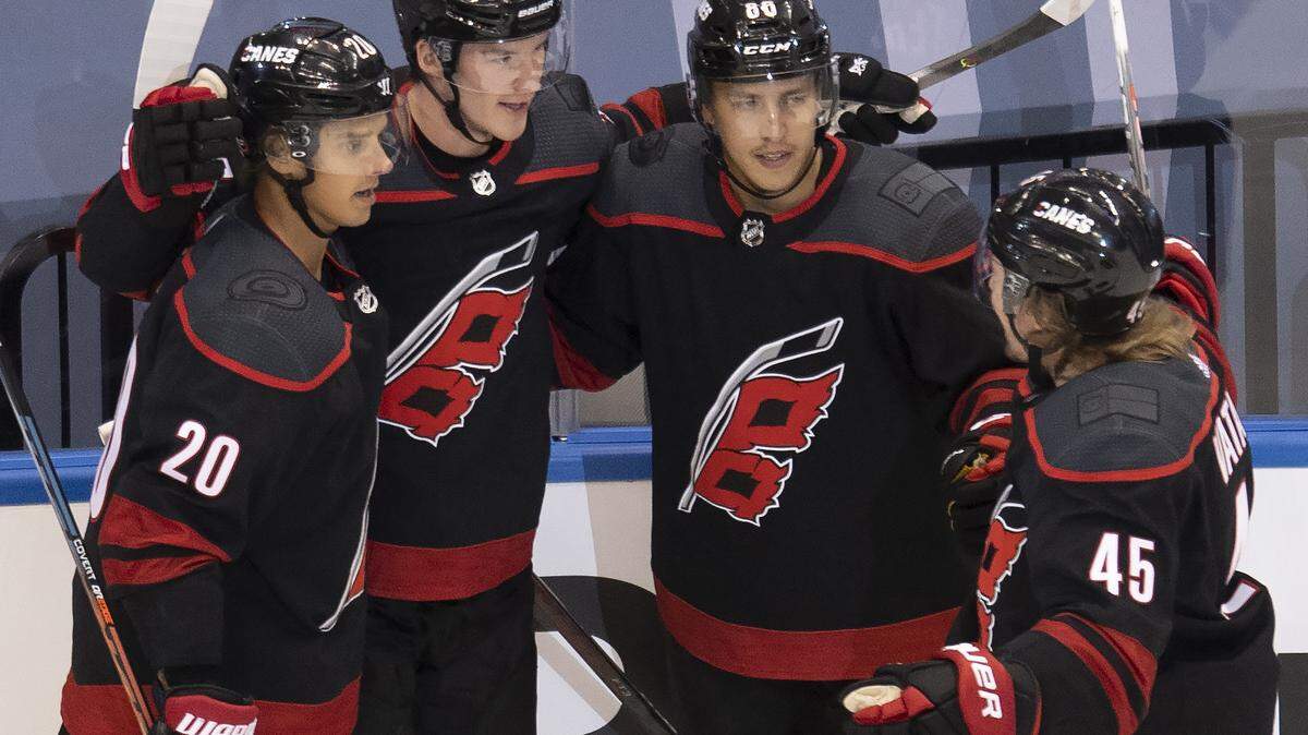 Carolina Hurricanes right wing Andrei Svechnikov (37) is congratulated teammates center Sebastian Aho (20), left wing Teuvo Teravainen (86) and defenseman Sami Vatanen (45) after scoring goal against the New York Rangers during the first period of an NHL Stanley Cup playoff hockey game in Toronto, Monday, Aug. 3, 2020. (Frank Gunn/The Canadian Press via AP)