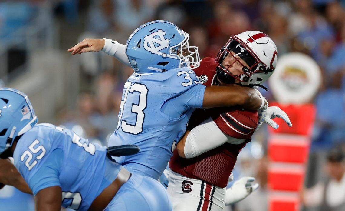 South Carolina quarterback Spencer Rattler (7) passes just as he is hit by North Carolina linebacker Cedric Gray (33) during the first half of UNC’s game against South Carolina in the Duke’s Mayo Classic at Bank of America Stadium in Charlotte, N.C., Saturday, Sept. 2, 2023.