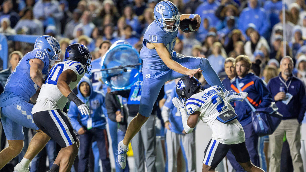 North Carolina quarterback Drake Maye (10) picks up 15-yards as he hurdles over Duke’s Jaylen Stinson (2) to set up a touchdown in the third quarter on Saturday, Nov. 11, 2023 at Kenan Stadium in Chapel Hill, N.C.