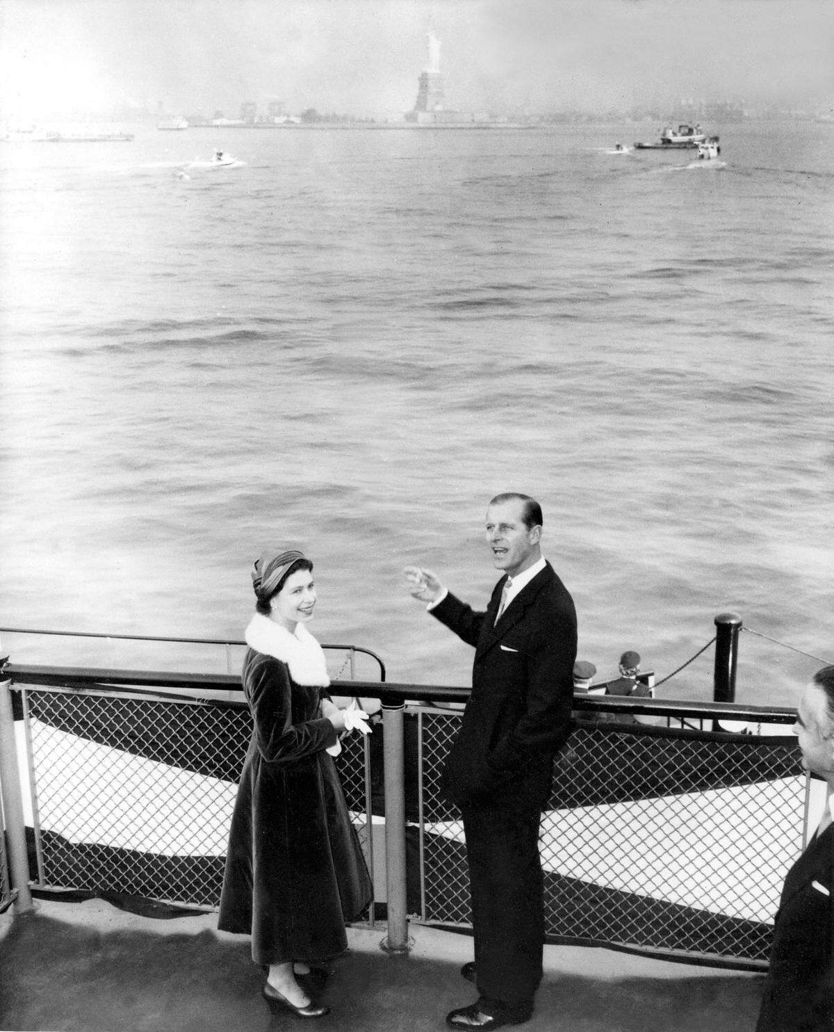 Queen Elizabeth turns and smiles while Prince Philip points and shouts something as the royal couple pass the famed Statue of Liberty on the Army ferryboat carrying them from Staten Island to Manhattan for their one-day visit to New York City, on Oct. 21, 1957.