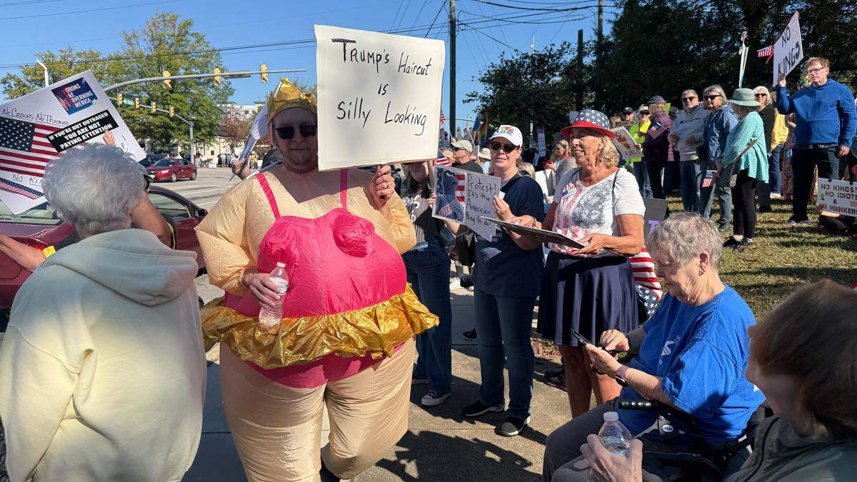 Protesters gather in Cary before the scheduled start time of No Kings protest, Saturday, October 18, 2025.