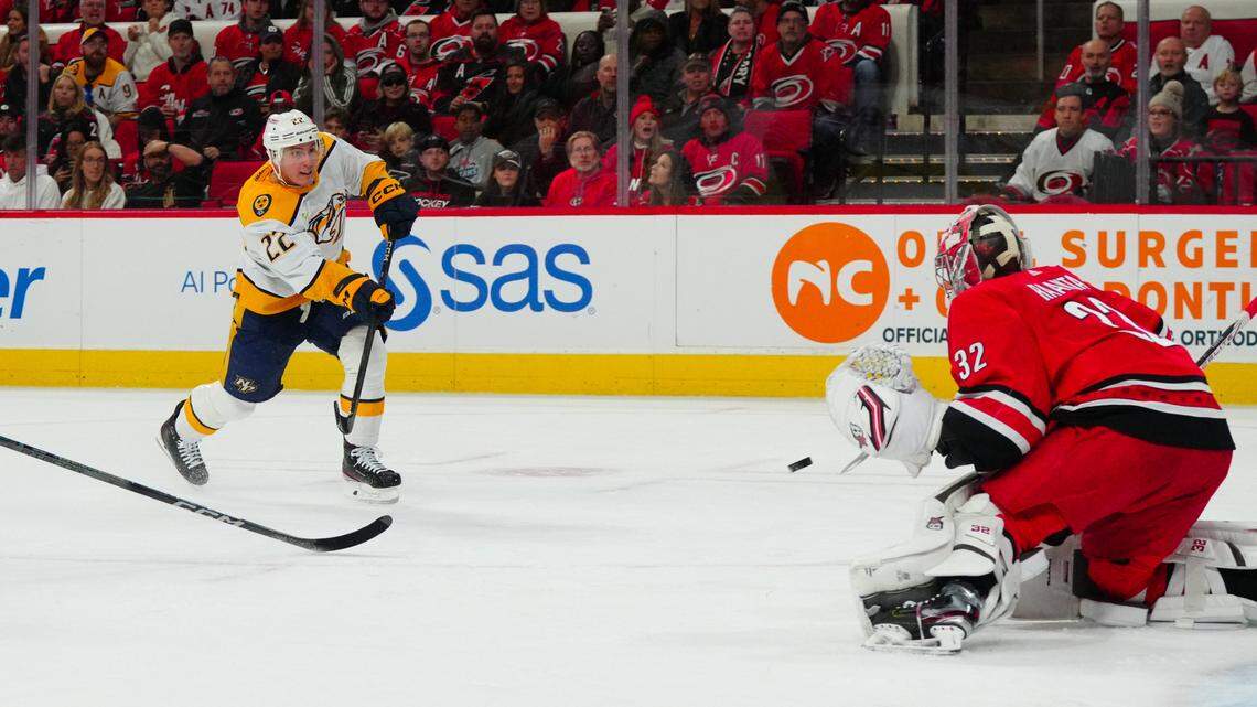 Dec 15, 2023; Raleigh, North Carolina, USA; Nashville Predators defenseman Tyson Barrie (22) scares a goal past Carolina Hurricanes goaltender Antti Raanta (32) during the second period at PNC Arena. Mandatory Credit: James Guillory-USA TODAY Sports