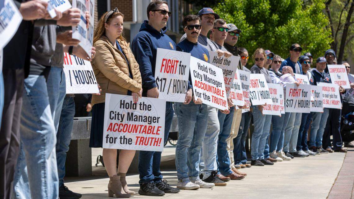 Karen Fanto stands with her husband, Raleigh firefighter Andre Fanto, right, and other police and fire personnel and their supporters outside City Hall, calling for an equitable pay increase on Tuesday, April 19, 2022 in Raleigh, N.C.