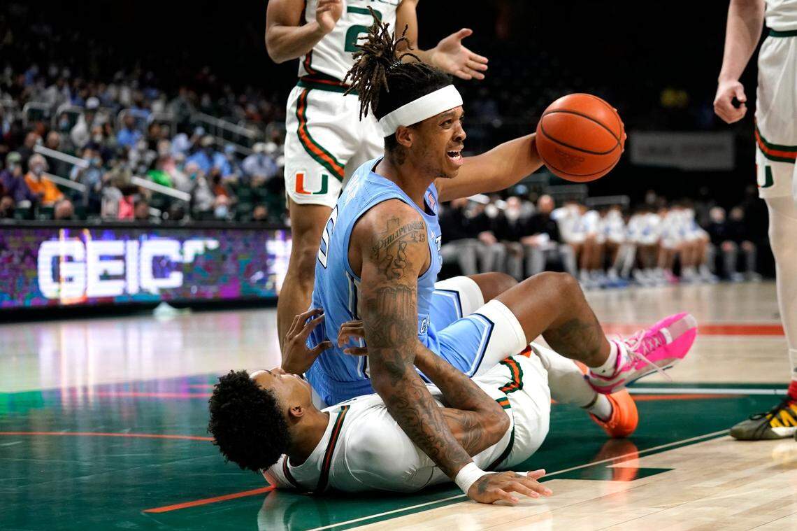 North Carolina forward Armando Bacot (5) commits a foul as Miami guard Jordan Miller falls to the court during the first half of an NCAA college basketball game, Tuesday, Jan. 18, 2022, in Coral Gables, Fla. (AP Photo/Lynne Sladky)