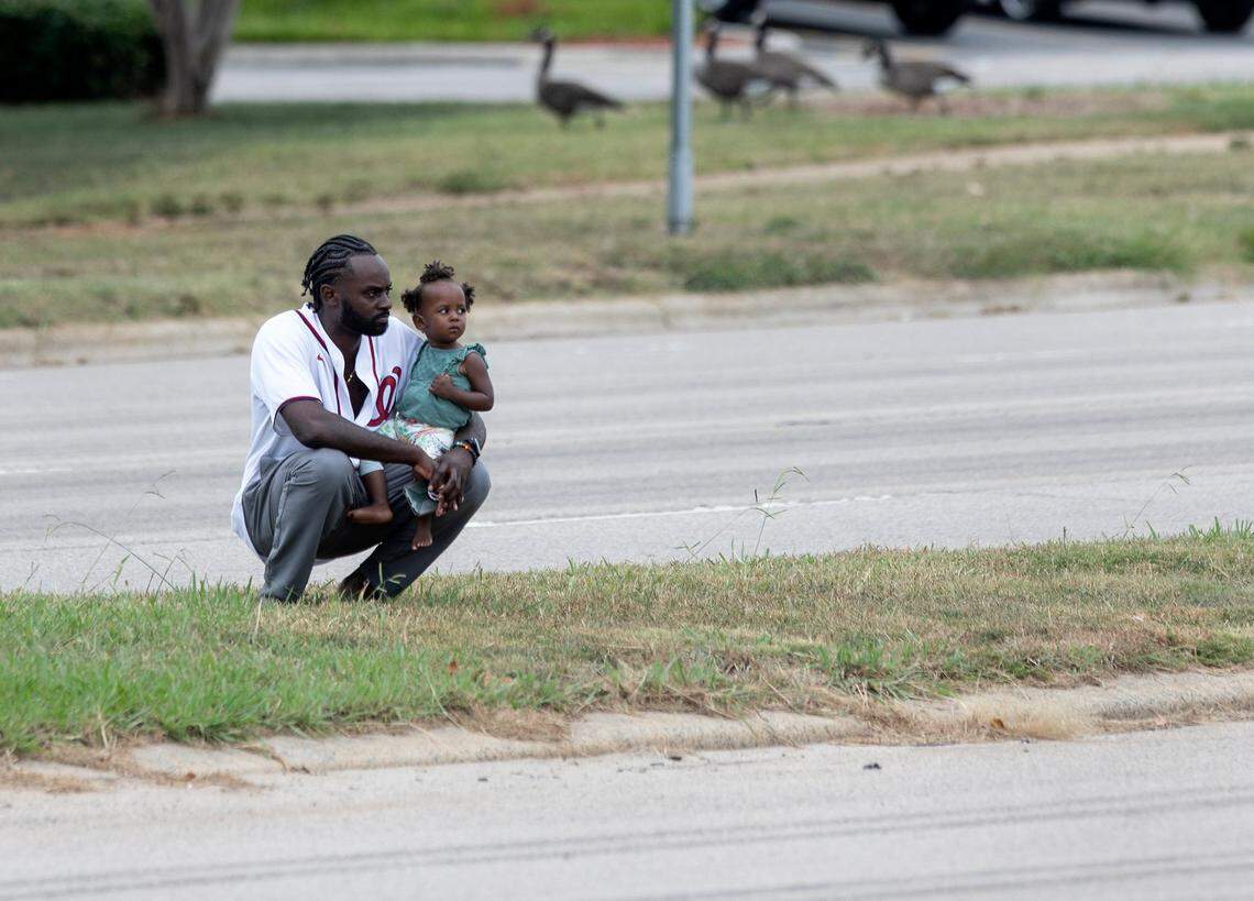 People watch from a median as the N.C. State Highway Patrols Caisson Unit carries the casket of slain Wake County Sheriffs Deputy Ned Byrd down Glenwood Avenue on Friday, Aug. 19, 2022, in Raleigh, N.C. Byrd was found dead with multiple gunshot wounds early Friday morning, Aug. 12 in southeastern Wake County.