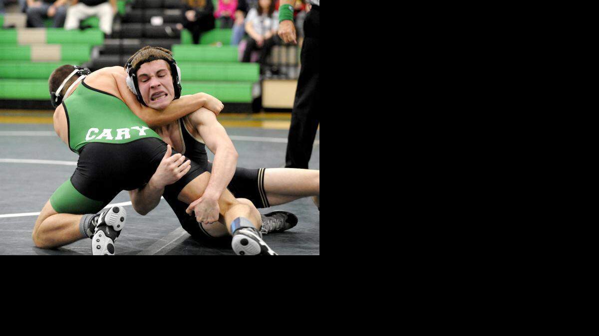 Holly Springs’ Joe Myers (right) and Cary's Ross Hillman wrestle in the 126-pound class during the match between the Holly Springs Golden Hawks and the Cary Imps in Cary on Wednesday, December 10, 2014. Holly Springs won 53-21.

