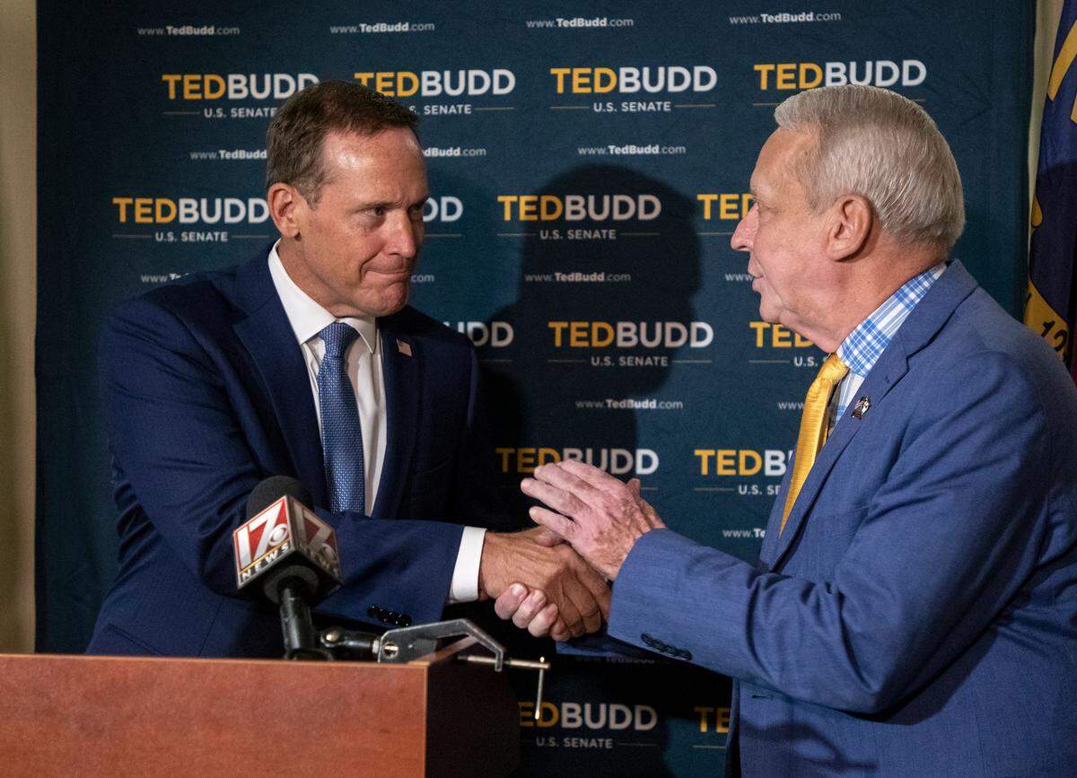 Republican Senate candidate Ted Budd shakes hands with former Wake County Sheriff Donnie Harrison during a press conference in Raleigh, N.C. on Friday, August 12, 2022.