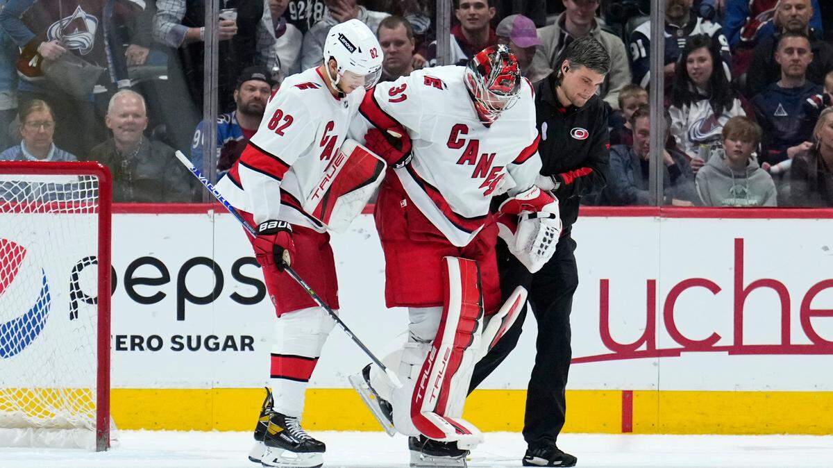 Carolina Hurricanes goaltender Frederik Andersen (31) is helped off the ice by Jesperi Kotkaniemi (82) and a trainer during the third period of the team’s NHL hockey game against the Colorado Avalanche on Saturday, April 16, 2022, in Denver. (AP Photo/Jack Dempsey)