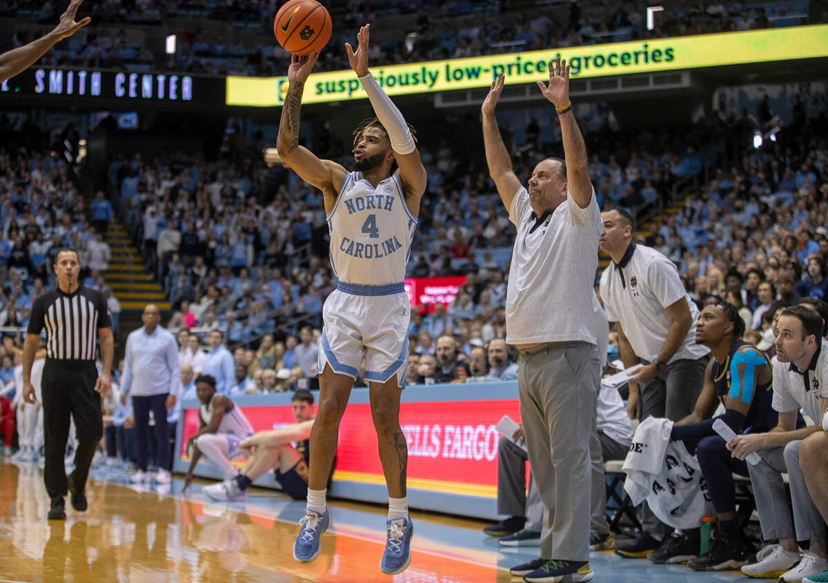 North Carolina’s R.J. Davis (4) launches a three point shot in front of Notre Dame coach Mike Brey during the first half on Saturday, January 7, 2023 at the Smith Center in Chapel Hill, N.C.