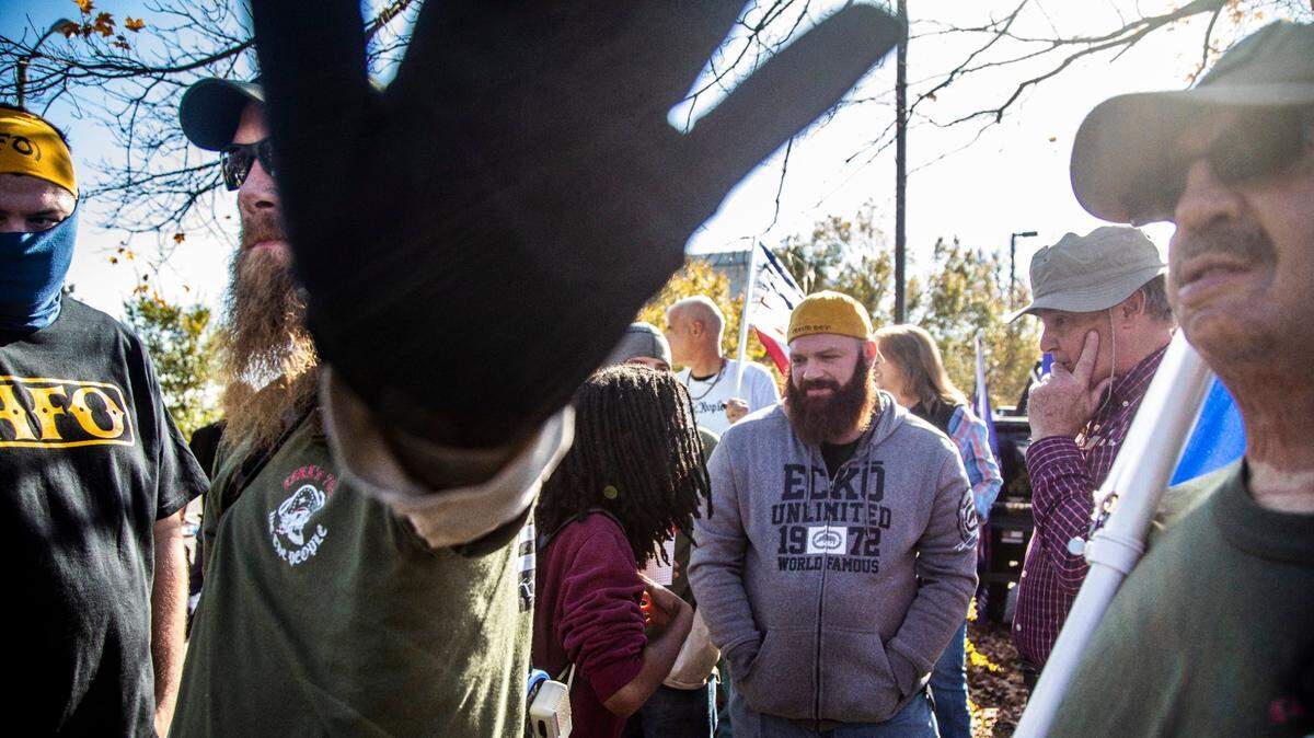 A man attempts to block a camera lens during a rally in support of President Donald Trump that included members of the Proud Boys Saturday, Nov. 28, 2020 in downtown Raleigh.