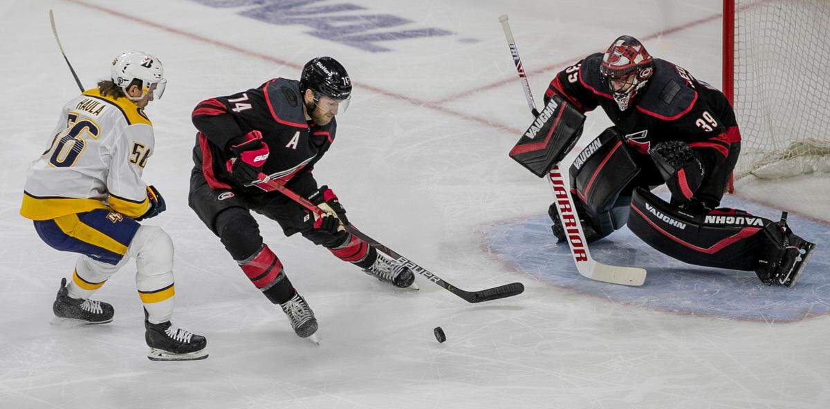 Carolina Hurricanes’ Jaccob Slavin (74) clears the puck from Nashville’s Erik Haula (56) in front of the Hurricanes goal in the first period of game five of their first round Stanley Cup Series on Tuesday, May 25, 2021 at PNC Arena in Raleigh, N.C.