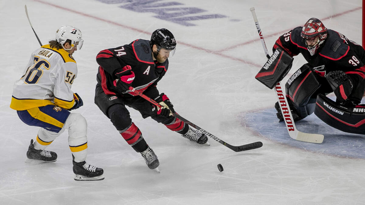 Carolina Hurricanes’ Jaccob Slavin (74) clears the puck from Nashville’s Erik Haula (56) in front of the Hurricanes goal in the first period of game five of their first round Stanley Cup Series on Tuesday, May 25, 2021 at PNC Arena in Raleigh, N.C.