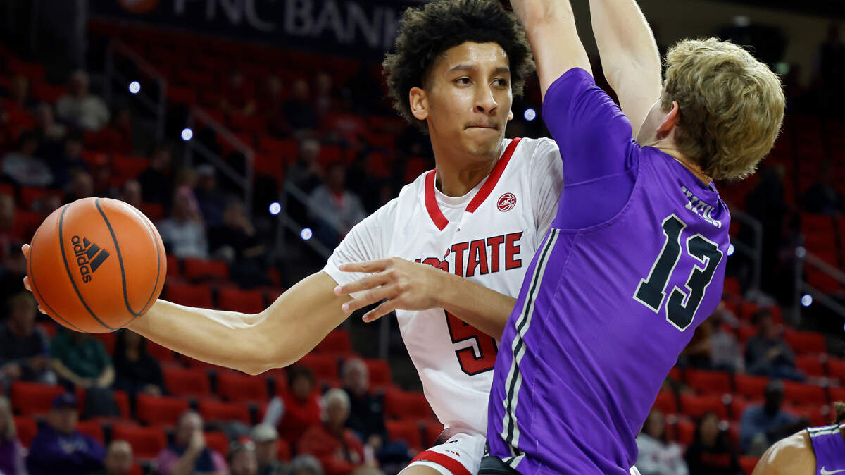 North Carolina State’s Jack Clark looks to pass around Furman’s Garrett Hien during the first half of a men’s basketball game at PNC Arena on Tuesday, Dec. 13, 2022, in Raleigh, N.C.