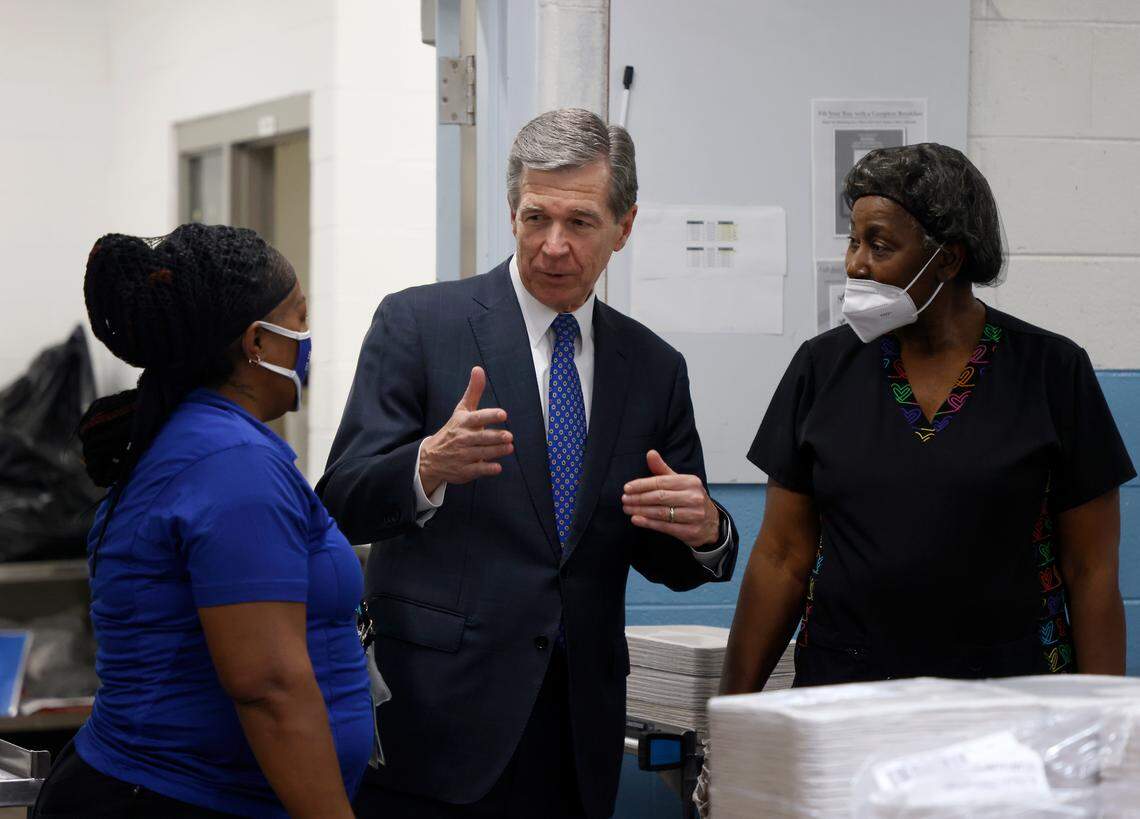 Gov. Roy Cooper speaks with cafeteria manager Tonya James and school nutrition assistant Brenda Seabrook at Bethesda Elementary School on Tuesday, Oct. 11, 2022, in Durham, N.C. Cooper visited the school to announce new agreements to bring food from North Carolina farmers and producers to schools.