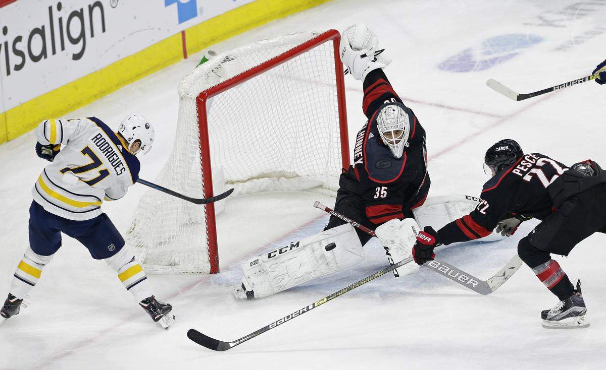 Carolina Hurricanes goalie Curtis McElhinney (35) and Brett Pesce (22) defend the goal against Buffalo Sabres’ Evan Rodrigues (71) during the third period of an NHL hockey game in Raleigh, N.C., Saturday, March 16, 2019. Carolina won 4-2. (AP Photo/Gerry Broome)