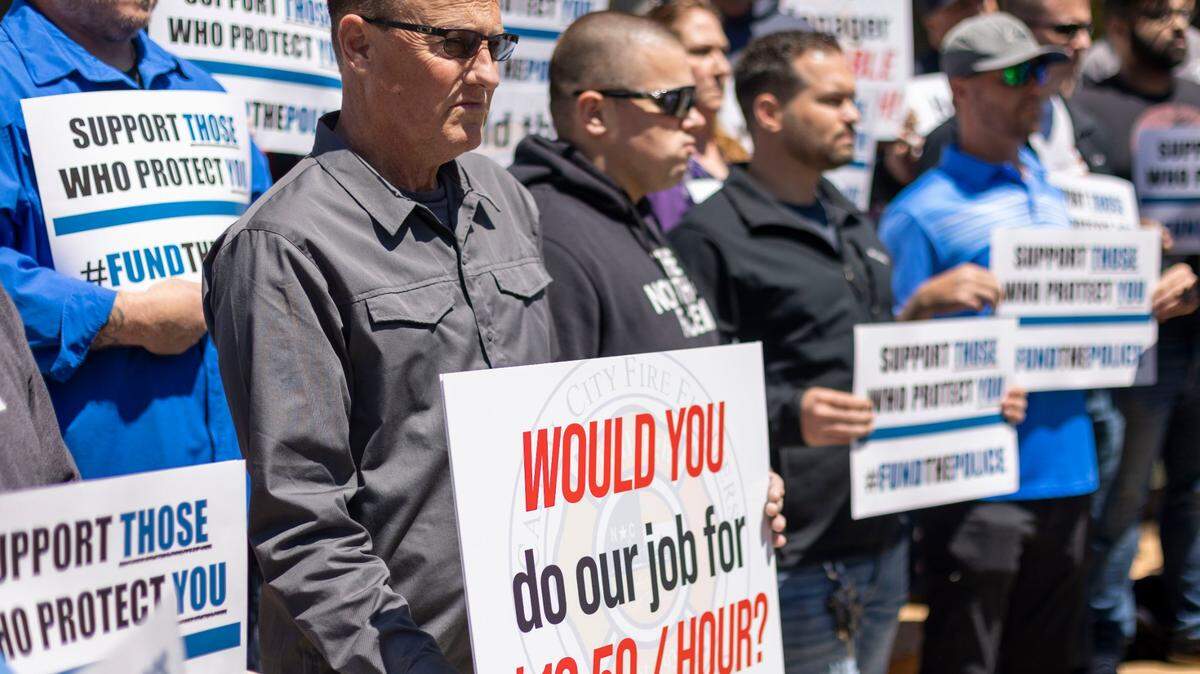 Scott Carpenter, a United Parcel driver, stands with Raleigh police and firefighters during a demonstration calling for higher wages on Tuesday, April 19, 2022 in Raleigh, N.C