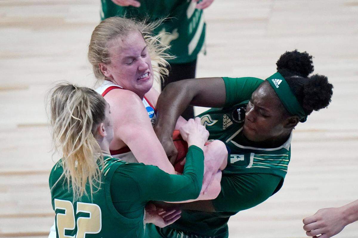 South Florida forward Kristyna Brabencova (22) and forward Bethy Mununga, right, fight for a loose ball with North Carolina State center Elissa Cunane during the first half of a college basketball game in the second round of the women’s NCAA tournament at the Alamodome in San Antonio, Tuesday, March 23, 2021.