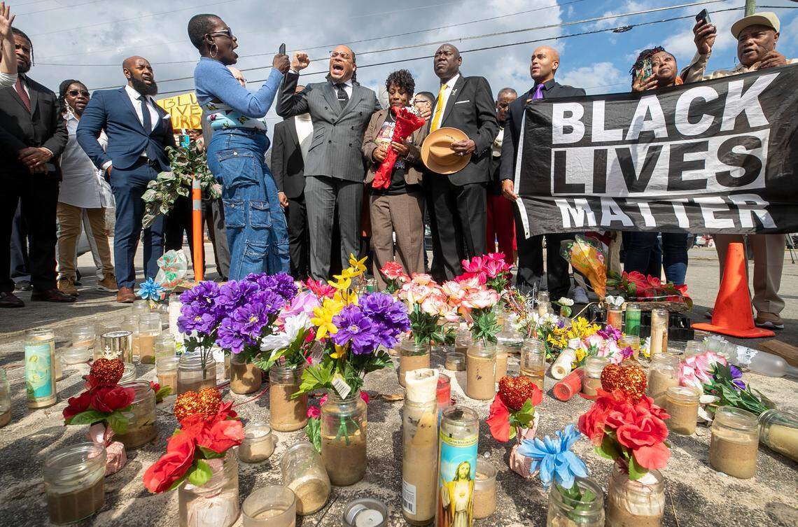 Rev. Greg Drumwright says a prayer moments before Sonya Williams laid a bouquet of flowers on a memorial for her son Darryl Williams on Rock Quarry Road on Thursday, February 16, 2023 in Raleigh, N.C. Williams died after being tased by Raleigh police in January.