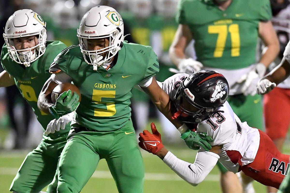 Cardinal Gibbons running back Kendall Scotton (5) rushes for yards against Rolesville’s Jovon Wright (13) during the first half. The Rolesville Rams and the Cardinal Gibbons Crusaders met in the East Regional Final of the NCHSAA 4A football playoffs in Raleigh, N.C. on December 13, 2024.