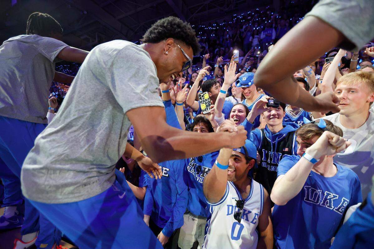 Duke’s Jeremy Roach and teammates jump onto the press row tables after being introduced to celebrate with the Cameron Crazies during Duke’s Countdown to Craziness at Cameron Indoor Stadium in Durham, N.C., Friday, Oct. 21, 2022.