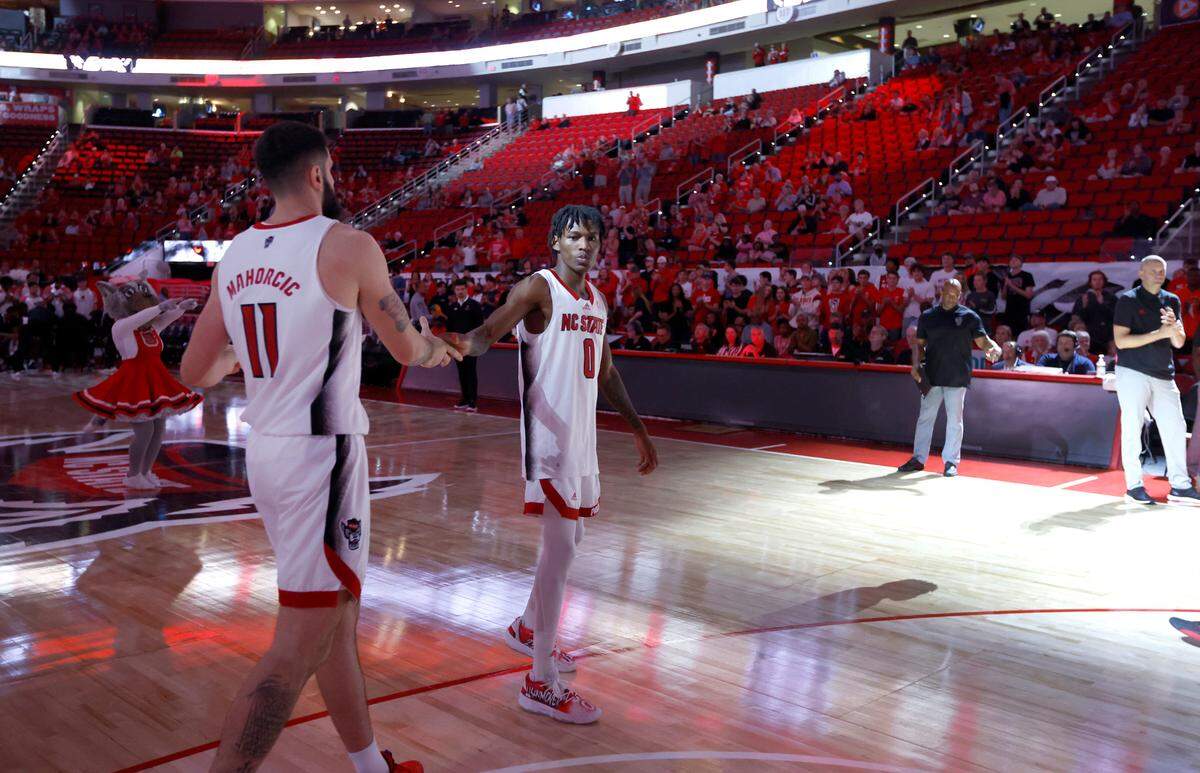 N.C. State’s Terquavion Smith (0) greets N.C. State’s Dusan Mahorcic (11) during player introductions before N.C. State’s season opening game against Austin Peay at PNC Arena in Raleigh, N.C., Monday, Nov. 7, 2022.