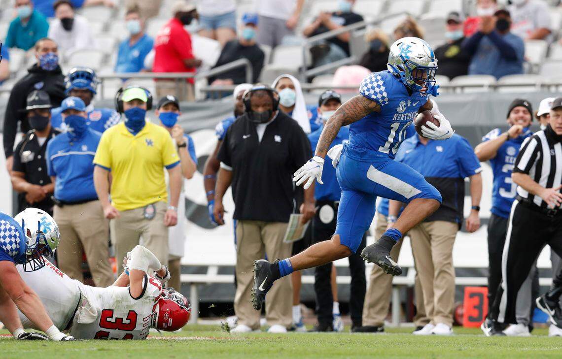 Kentucky running back Asim Rose Jr. (10) escapes from N.C. State cornerback Isaac Duffy (33) during the second half of Kentucky’s 23-21 victory over N.C. State in the Gator Bowl at TIAA Bank Field in Jacksonville, Fla., Saturday, January 2, 2021.