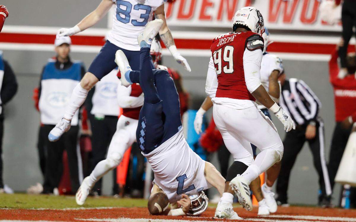 North Carolina quarterback Sam Howell (7) dives in to score on 12-yard run during the second half of N.C. State’s 34-30 victory over UNC at Carter-Finley Stadium in Raleigh, N.C., Friday, November 26, 2021.