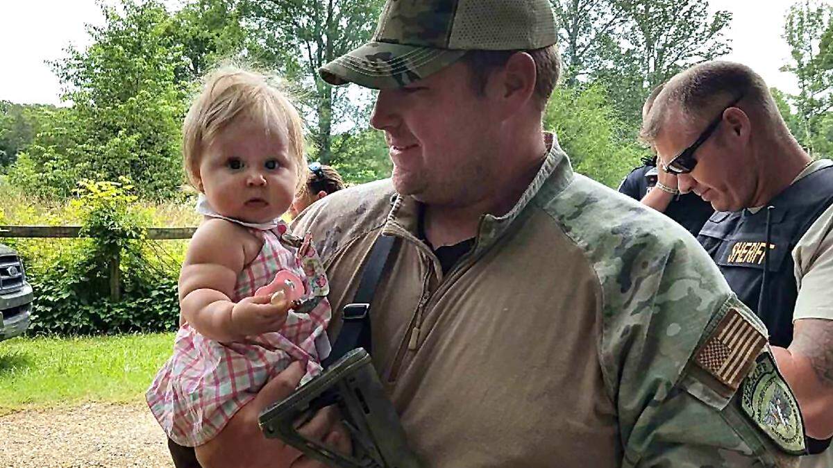 Randolph County Deputy Jimmy Barnes holds baby Emma Grace Kennedy after she was found safe in Randleman, NC. The girl was abducted Sunday by her father, Carl Ray Kennedy, a registered sex offender, police say.