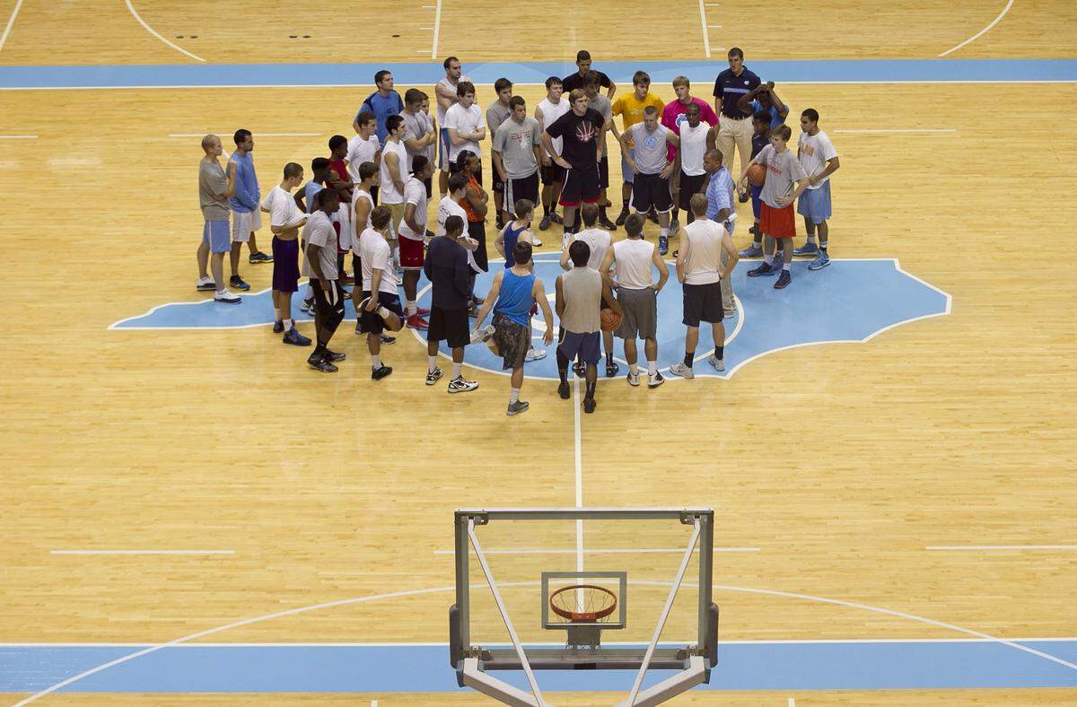 UNC JV basketball coach Hubert Davis huddles with those trying out for the team on the first of two days of tryouts on Thursday October 3, 2013 at the Smith Center in Chapel Hill, N.C.