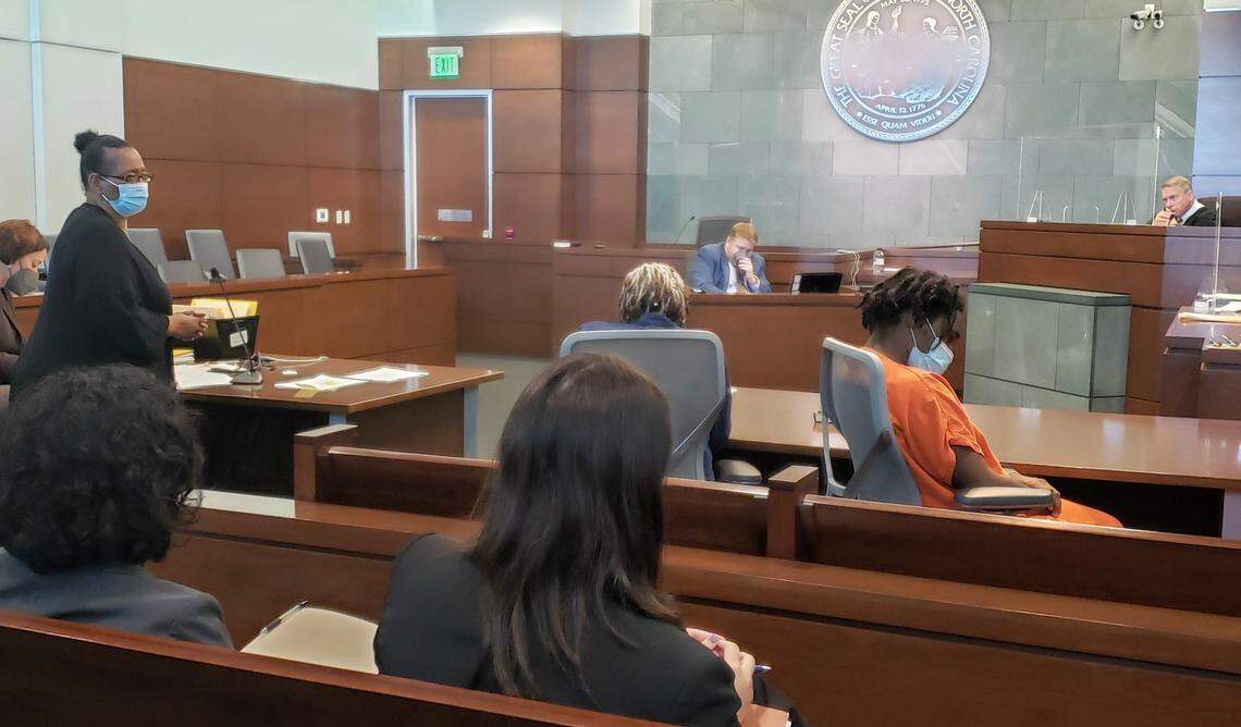 Larico Dunn, right in orange, looks away from Wanda Elaine Downey, left, as she speaks to the court on Oct. 26, 2021 about how her family were affected after Dunn killed her 25-year-old daughter Erika Desiree Downey in Septmeber 2016.