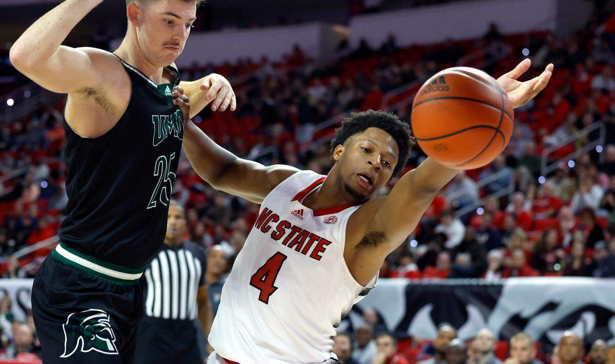 N.C. State’s LJ Thomas (4) goes after the loose ball during the second half of N.C. State’s 89-76 exhibition victory over Mount Olive at PNC Arena in Raleigh, N.C., Wednesday, Nov. 1, 2023. Mount Olive’s Colin Radcliffe (25) is to the left.