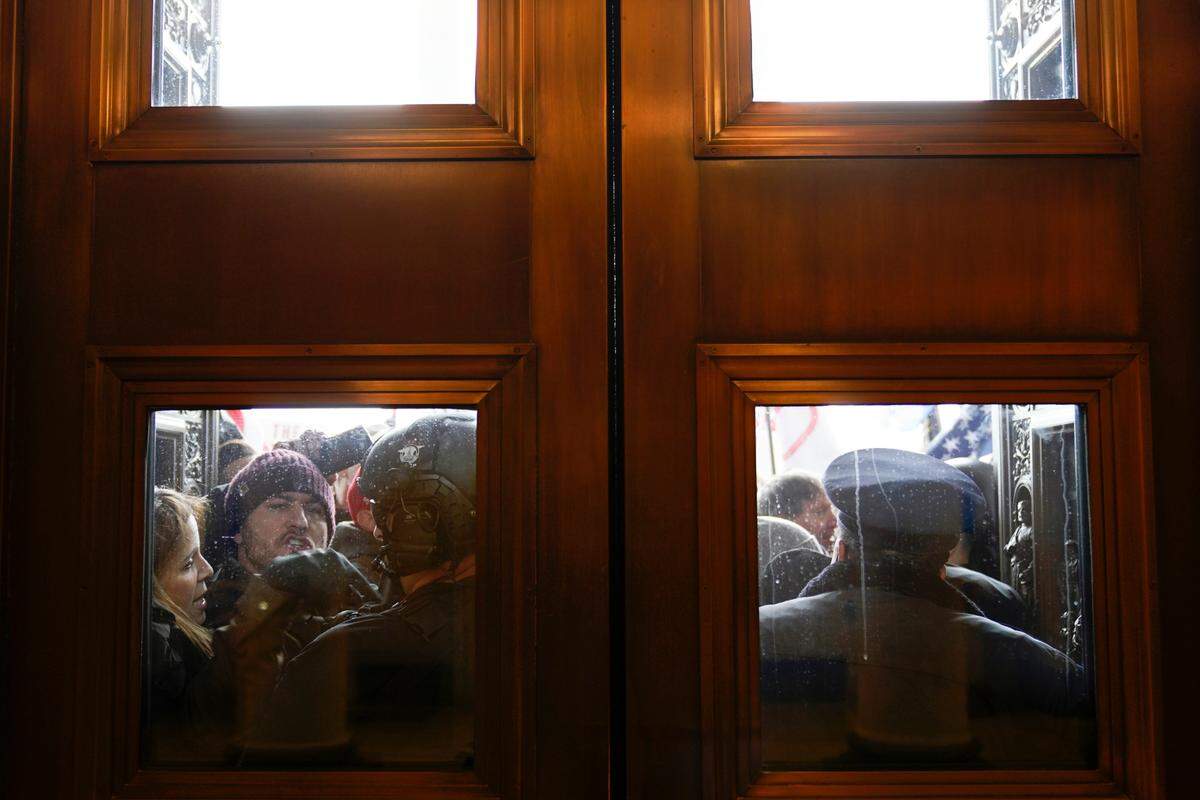 U.S. Capitol Police try to hold back rioters outside the east doors to the House side of the U.S. Capitol, Jan 6, 2021. 