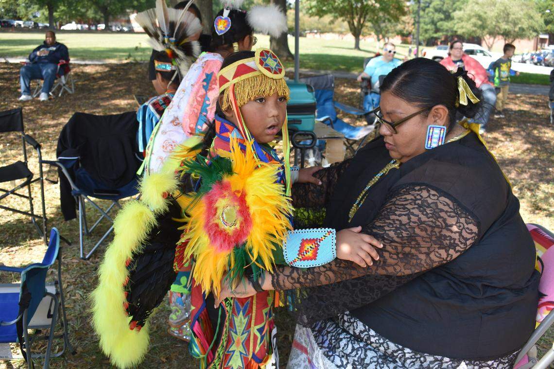 Crystal Tortalita helps her son, Caiden Tortalita, get ready to compete at the Inter-Tribal Pow Wow at Dix Park.