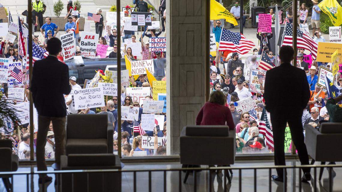 ReOpenNC protestors gather around the entrance of the North Carolina General Assembly building in the minutes before the House and the Senate were scheduled to begin their sessions on Tuesday, Apr. 28, 2020, in Raleigh, N.C.