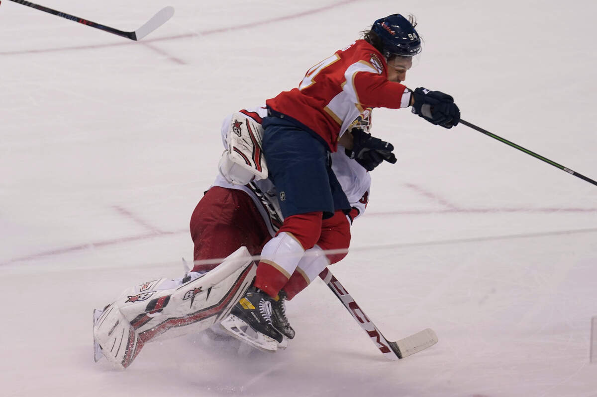 Florida Panthers left wing Ryan Lomberg (94) collides with Carolina Hurricanes goaltender Antti Raanta (32) during the second period at an NHL hockey game, Saturday, Nov. 6, 2021, in Sunrise, Fla. (AP Photo/Marta Lavandier)