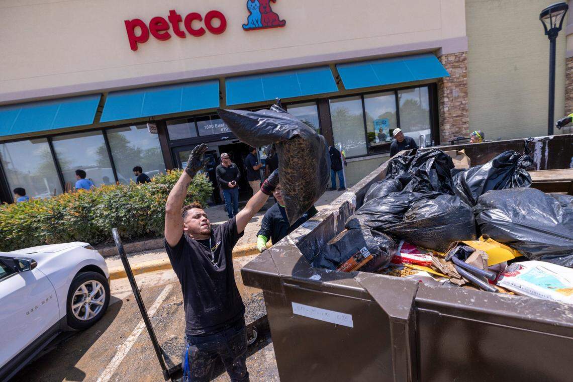 Workers discard thousands of dollars worth of flooded pet food and supplies at a Petco in Eastgate Crossing in Chapel Hill on Monday, July 7, 2025, after floodwaters caused by Tropical Storm Chantal surged about 5 feet inside businesses at the shopping center.