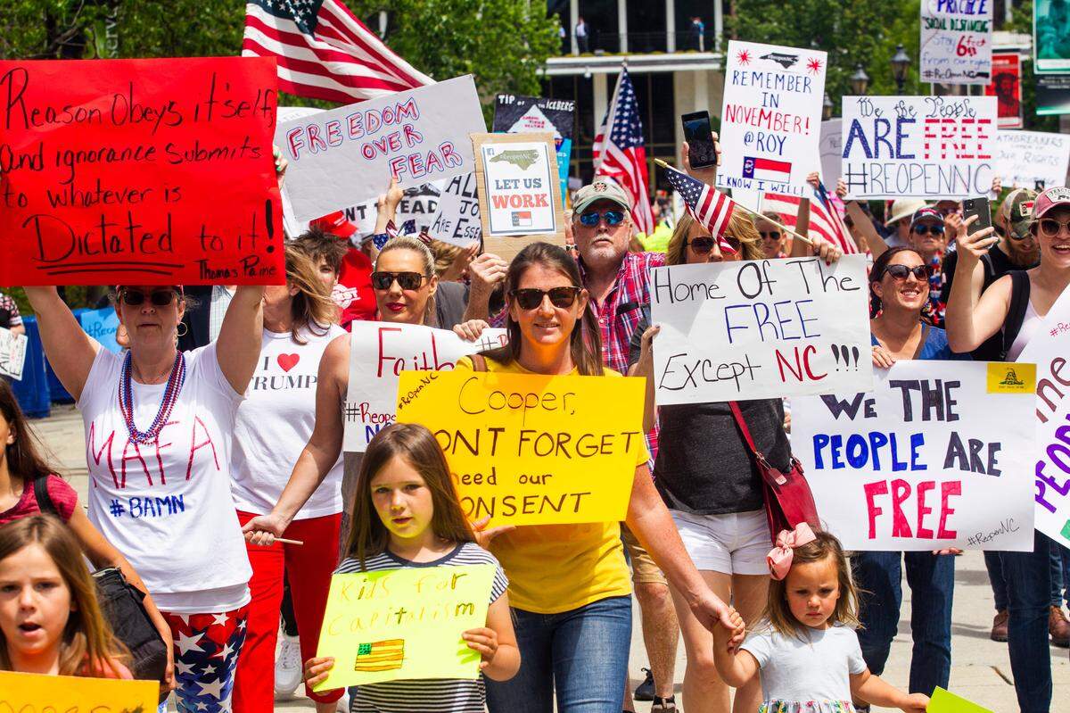 Protesters march during a Reopen NC rally in downtown Raleigh Tuesday, April 28, 2020. Protesters were calling for Gov. Roy Cooper to end the restrictions put in place because of the coronavirus pandemic.