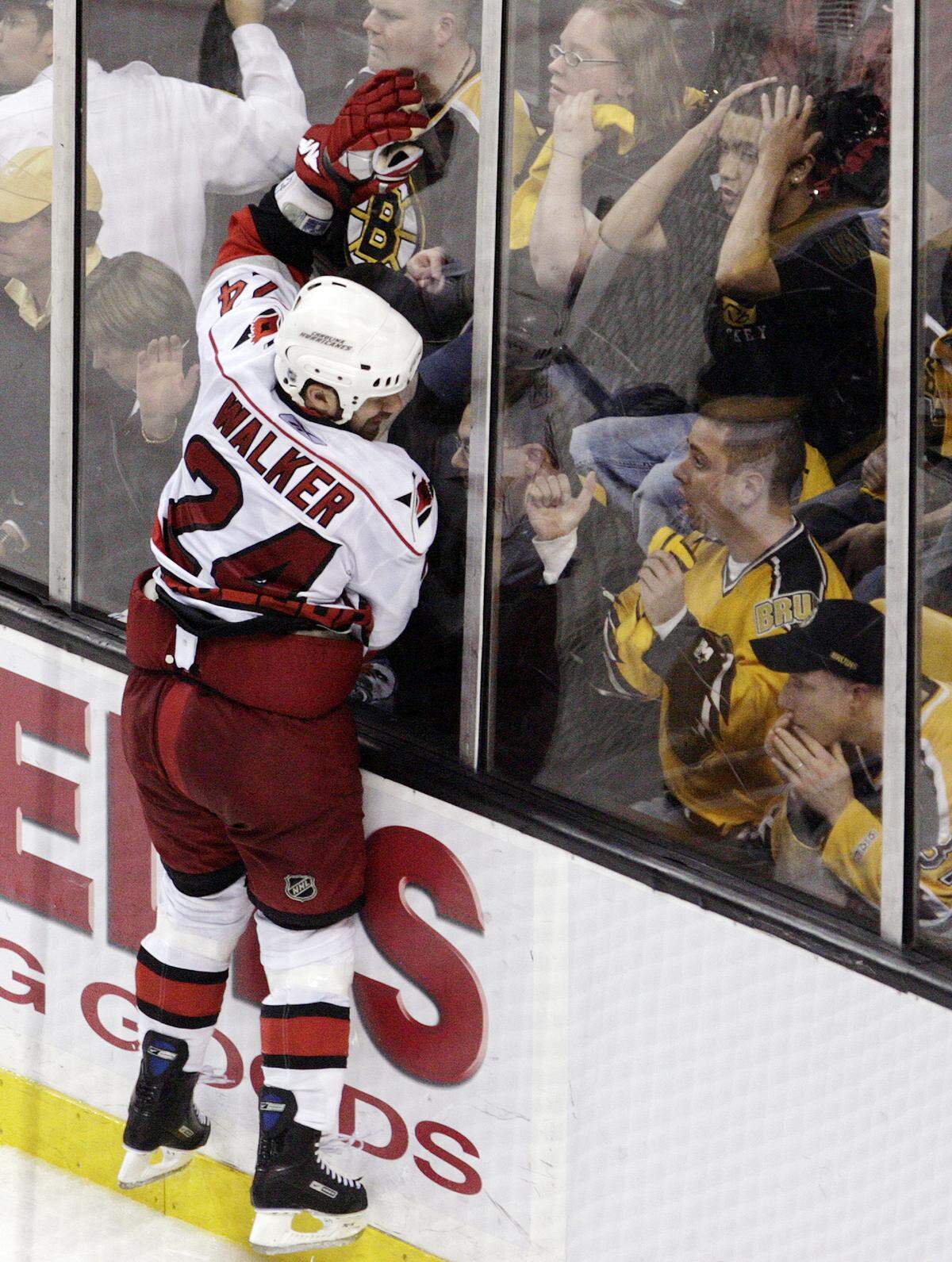 The Bruins’ fans react as the Carolina Hurricanes’ Scott Walker (24) throws himself against the glass after he scored the game winning goal during overtime action of Game 7 in 2009.