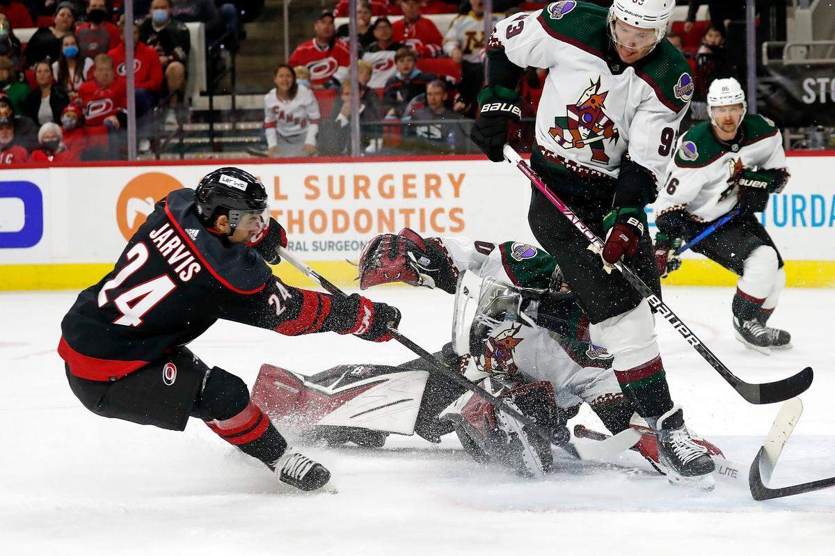 Carolina Hurricanes’ Seth Jarvis (24) has his shot blocked by Arizona Coyotes’ Dmitrij Jaskin (93) and goaltender Karel Vejmelka (70) during the second period of an NHL hockey game in Raleigh, N.C., Sunday, Oct. 31, 2021. (AP Photo/Karl B DeBlaker)