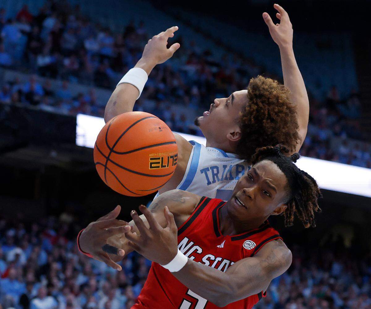 North Carolina’s Seth Trimble and N.C. State’s Trey Parker battle for a rebound during the first half of the Wolfpack’s game on Wednesday, Feb. 19, 2025, at the Smith Center in Chapel Hill, N.C.