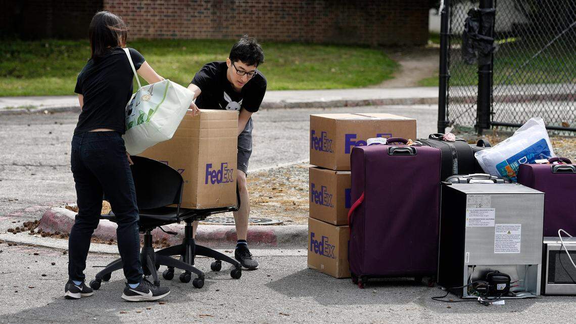 Duke freshmen Feng Cong from Singapore and Cassie Lu (left) from Thailand carry a box to a pile of their belongings as they move out of his dorm at Duke University. Sunday, March 15, 2020. Cong will be returning home to Singapore and Lu to Thailand since students are being asked to move out and complete classes online for the rest of the semester due to coronavirus.